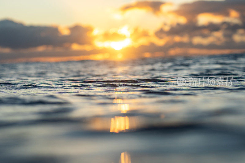 Sunrise reflecting off the surface of the ocean in golden light